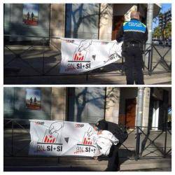 Un policia municipal de Reus retirant una pancarta a favor del Sí-Sí de la CUP 