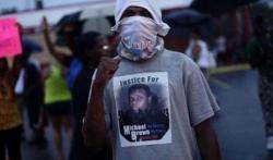 Un manifestant amb una samarreta amb la imatge del jove mort per la policia a Ferguson