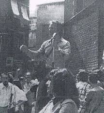 Durant la càrrega policial Carles Castellanos demana al públic que no marxi de l'acte del passeig del Born (9/9/1979). A primer terme es pot veure la militant d'IPC Mait Carrasco.