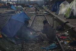 Dos homes descansen al costat de les vies del tren prop del camp de refugiats d'Idomeni, a la frontera de Grècia amb Macedònia. Foto: Crític / Xavi Herrero