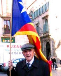 Josep Planchart, ja gran, amb l'estelada a la plaça sant Jaume