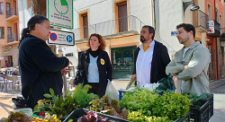 Els candidats de la CUP, Dani Cornellà i Montserrat Vinyets (al centre), acompanyats del conseller comarcal Àlex Medrano, al mercat de Sant Joan de les Abadesses.