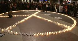 200 de persones han dibuixat un símbol de la pau de 15 metres amb espelmes a la plaça de Catalunya