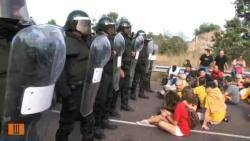 Agents antiavalots de la Guardia Civil davant d'alguns manifestants que impedien el pas dels furgons que portaven els detinguts. Font: Vilaweb