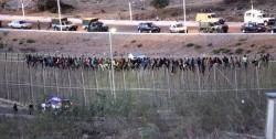 Desenes de subsaharians eren dalt de la tanca fronterera de Melilla