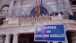 Foto de la gran pancarta en forma de placa de carrer amb el nom de Guillem Agulló i l?escut de la ciutat de València FOTO: El Postiguet