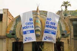 La papallona modernista que corona el bloc ha estat tapada parcialment amb dues pancartes fent una crida a la manifestaci&oacute; de dem&agrave;. Foto: SHSC.